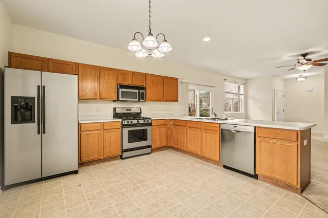 a kitchen with granite countertop stainless steel appliances cabinets a sink and a center island
