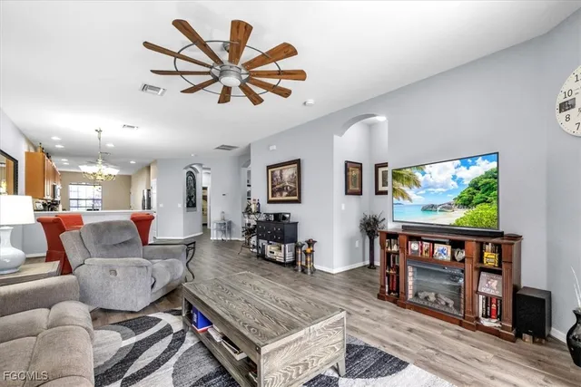 a living room with furniture a ceiling fan and a bookshelf