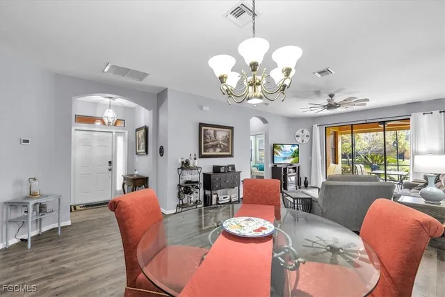 a view of a dining room with furniture a chandelier and wooden floor