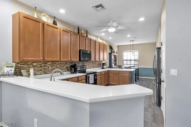 a kitchen with stainless steel appliances a sink a stove a refrigerator cabinets and a counter top space