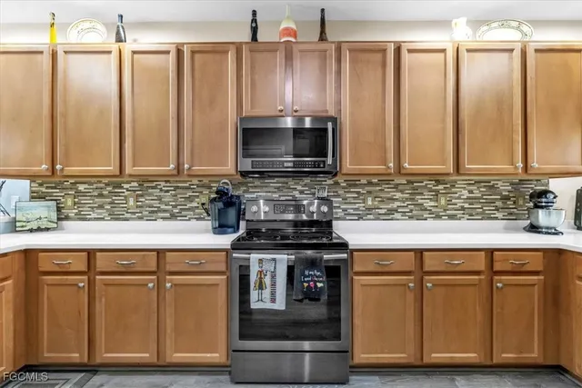 a kitchen with granite countertop a stove a sink and a microwave