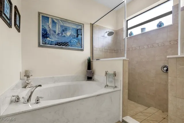a bathroom with a tub a sink and glass door