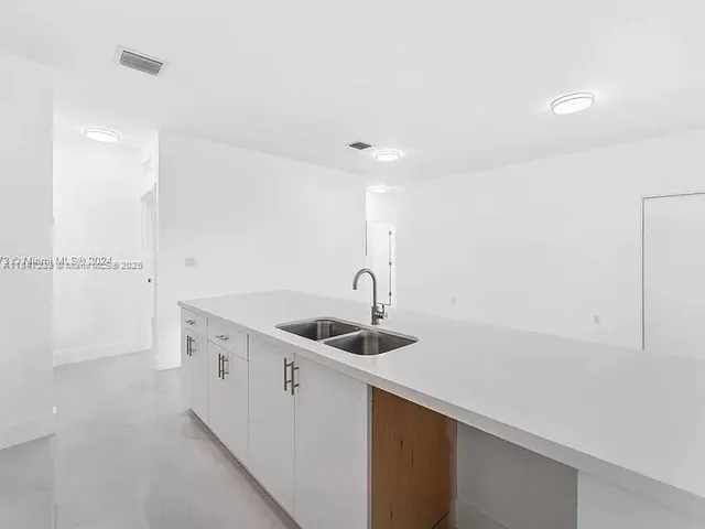 a large white kitchen with a sink