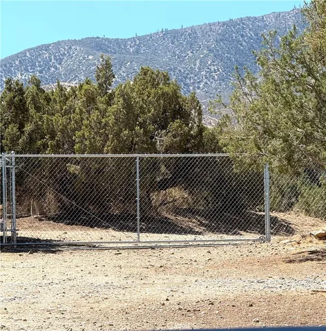 a view of a tennis court and trees on the side of the road