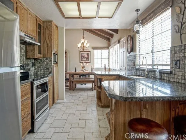 a kitchen with stainless steel appliances granite countertop a stove a sink and a microwave