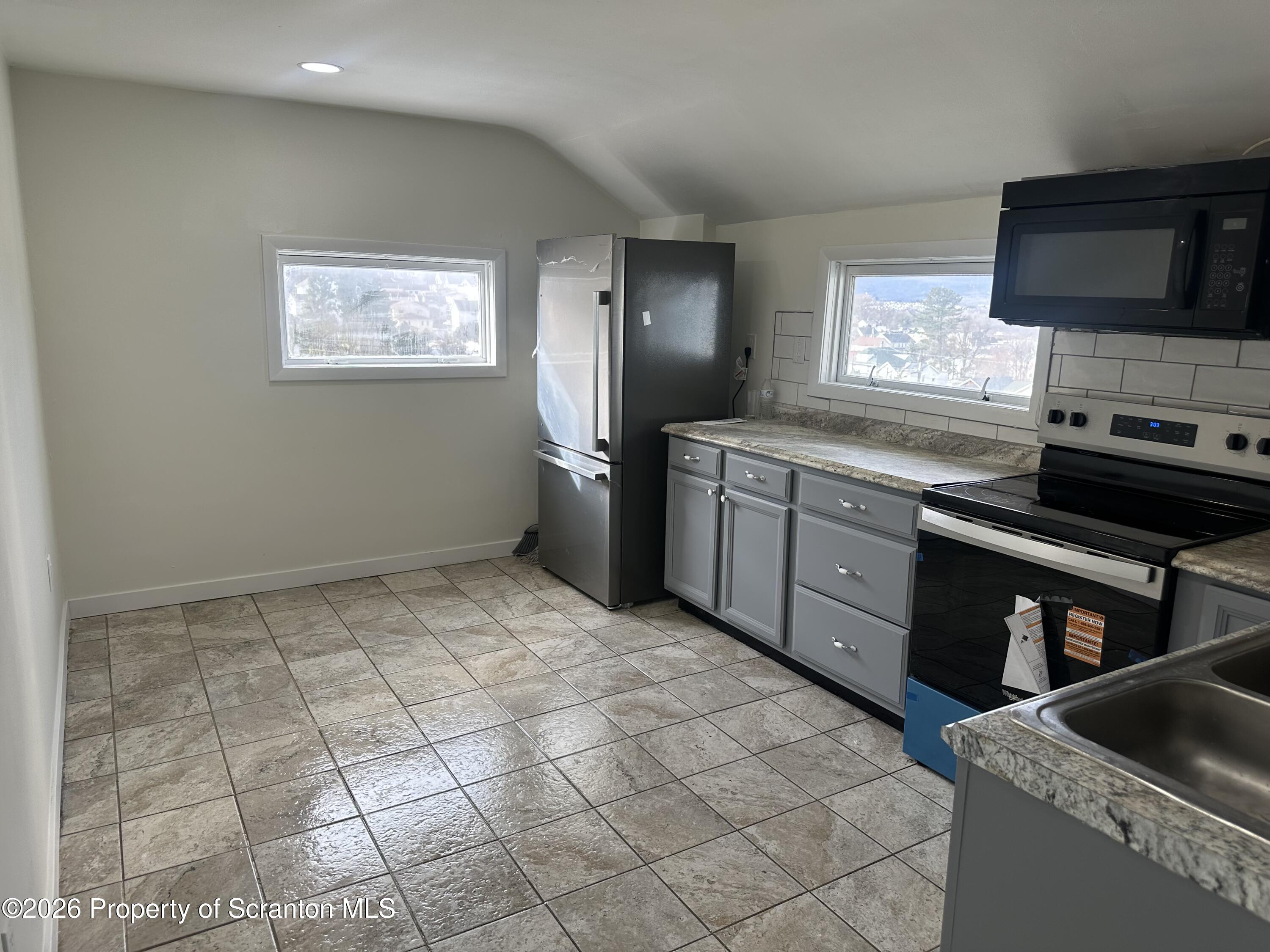 a kitchen with stainless steel appliances granite countertop a sink and a stove top oven