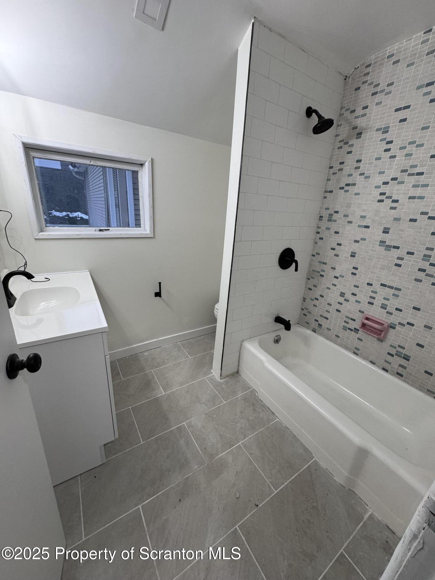 638 Pear Street, Unit 2 Scranton, PA 18505 - Photo 5 of 10 a bathroom with a sink a toilet and shower