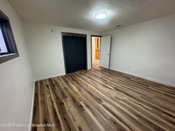 a view of a room with wooden floor