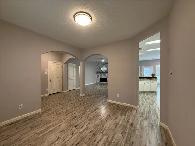an empty room with wooden floor and mirror