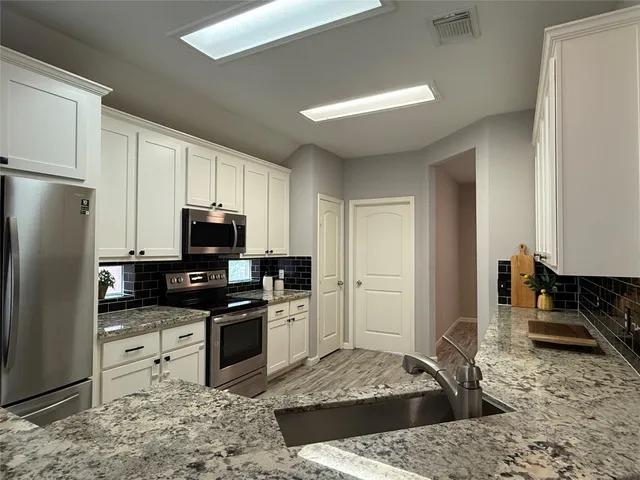 a kitchen with a refrigerator sink and stove