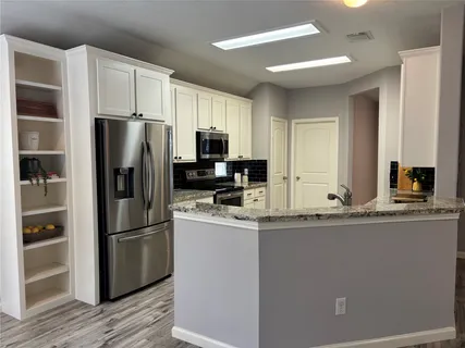 a kitchen with kitchen island a refrigerator sink and wooden cabinets