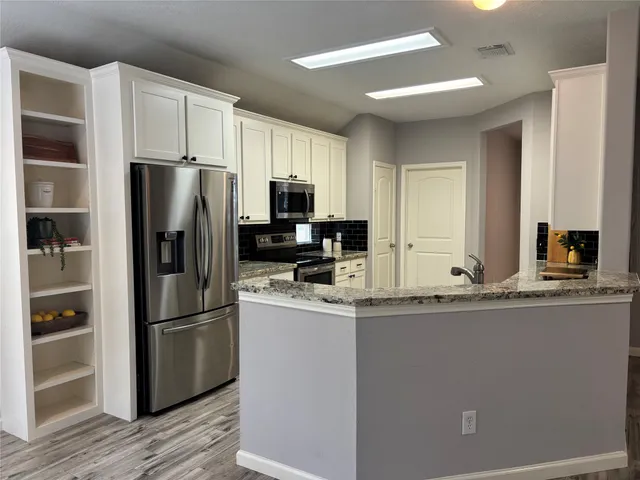 a kitchen with kitchen island a refrigerator sink and wooden cabinets