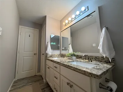 a bathroom with a granite countertop sink and a mirror