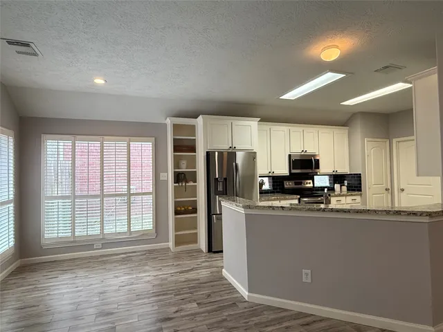a kitchen with stainless steel appliances a refrigerator sink and microwave
