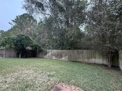a view of backyard with wooden fence