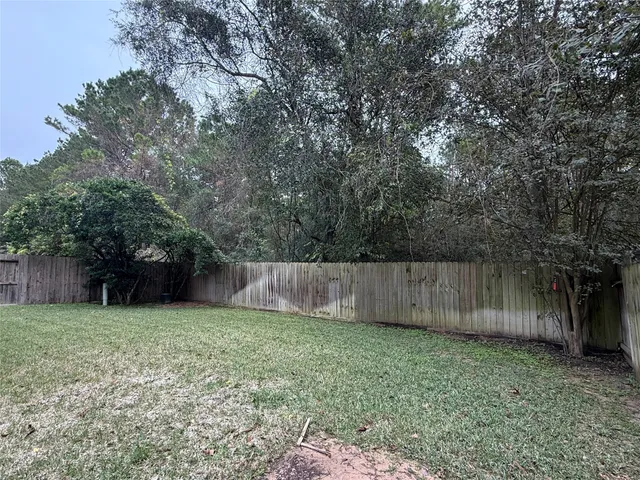 a view of backyard with wooden fence