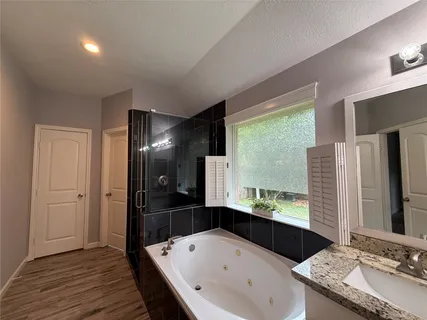 a bathroom with a granite countertop sink and a large mirror