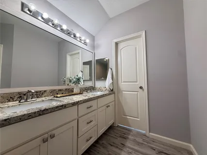 a bathroom with a double vanity and a mirror
