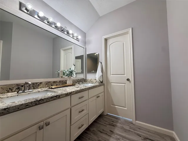 a bathroom with a double vanity and a mirror