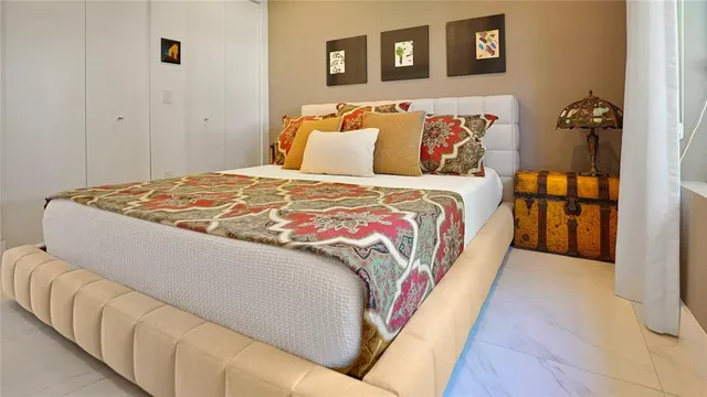 a bedroom with a bed and painting on the wall