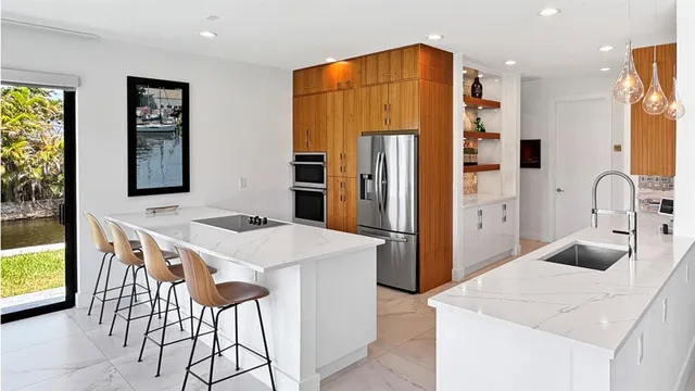 a kitchen with stainless steel appliances a stove a refrigerator a sink and a refrigerator