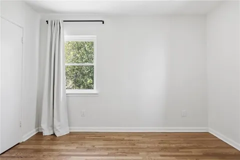 a view of a room with wooden floor and a window