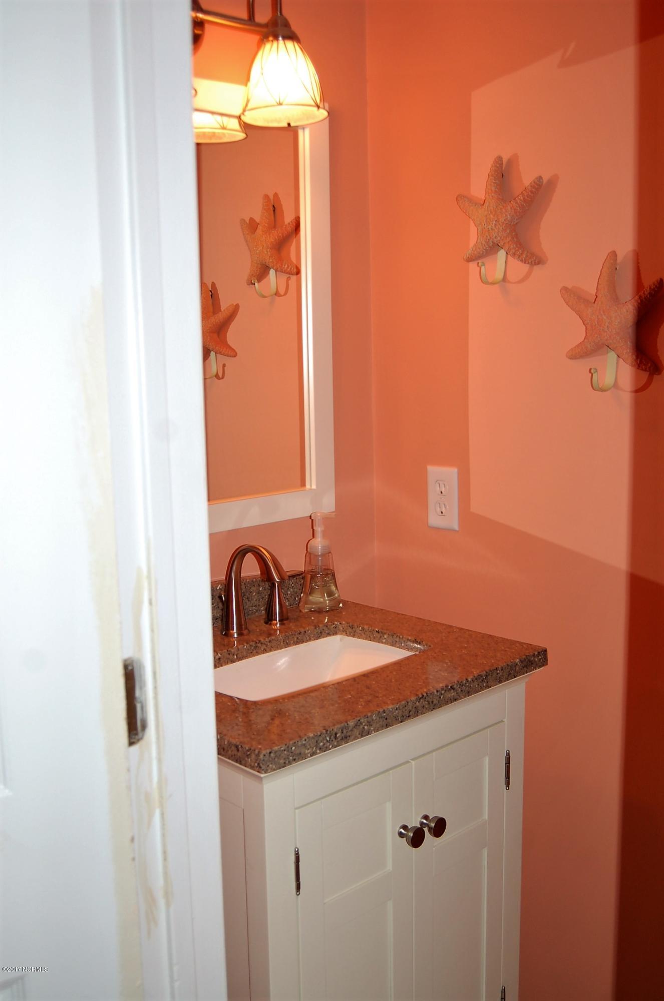 706 Stately Pines Road New Bern, NC 28560 - Photo 11 of 28 Updated half bath located on first floor. Features custom lighting, vanity and tile floors