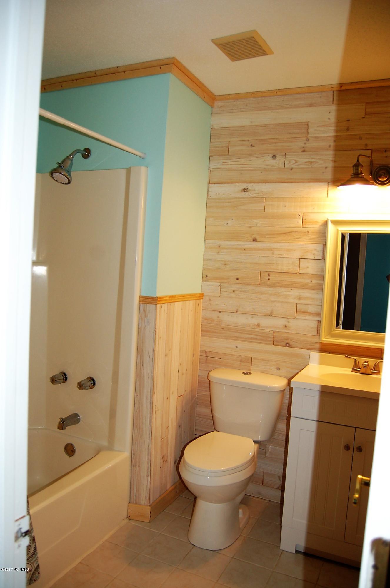 706 Stately Pines Road New Bern, NC 28560 - Photo 20 of 28 Wow what a great bathroom! Features ship lap walls, shower/tub combo, tile floors, new commode, vanity, mirror and lighting