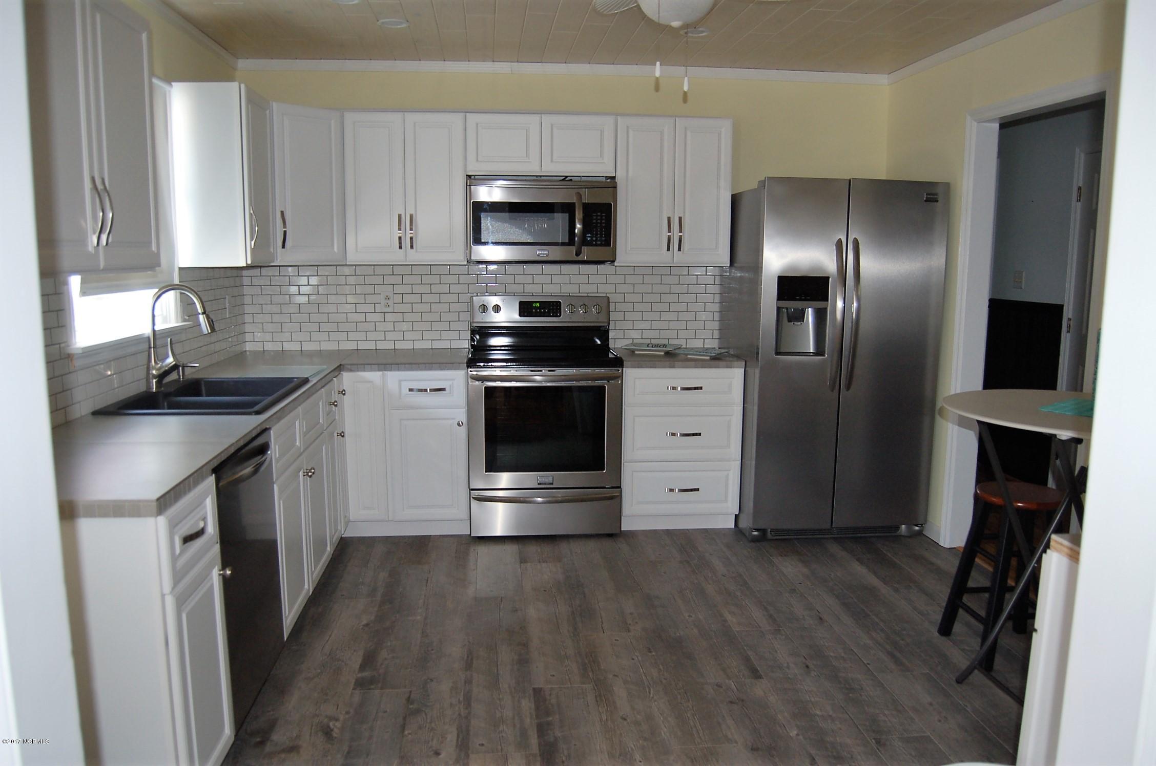 706 Stately Pines Road New Bern, NC 28560 - Photo 23 of 28 What an amazing kitchen! Lots of personal touches with ceramic tile flooring, smudge proof stainless appliances, custom white cabinets and a ship lap ceiling with recessed lighting