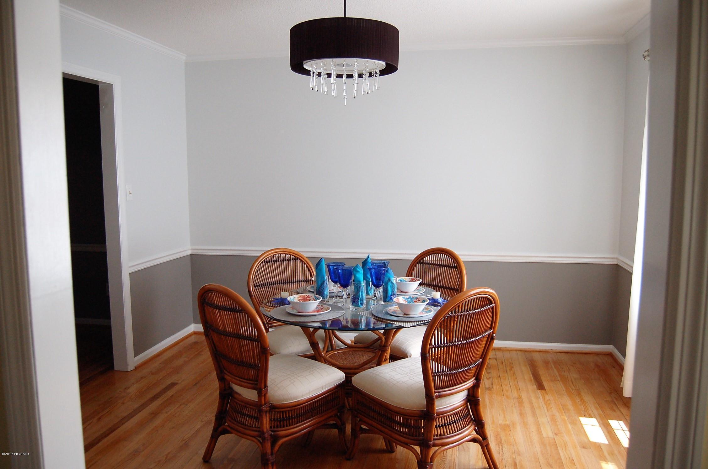 706 Stately Pines Road New Bern, NC 28560 - Photo 9 of 28 Bright and airy dining room w/large window overlooking the deck and pool. This room features hardwood floors, custom paint, chair rail and crown moulding.