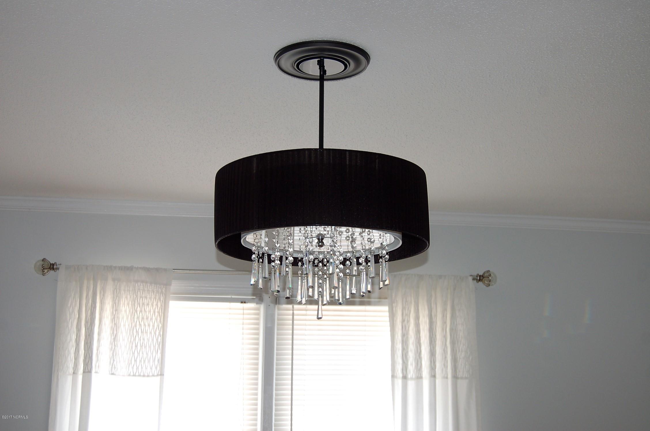 706 Stately Pines Road New Bern, NC 28560 - Photo 10 of 28 The dining room has a fantastic modern chandelier that adds warmth and charm.