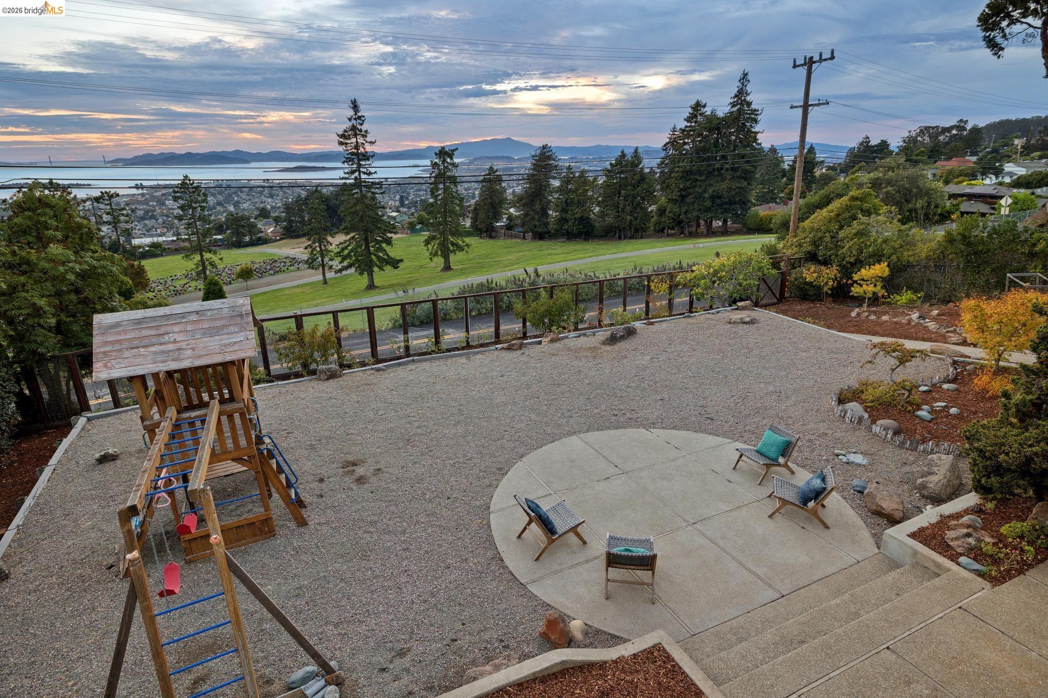 38 Highgate Road Kensington, CA 94707 - Photo 55 of 78 Expansive outdoor area featuring a gravel surface, a circular concrete patio, and mature landscaping