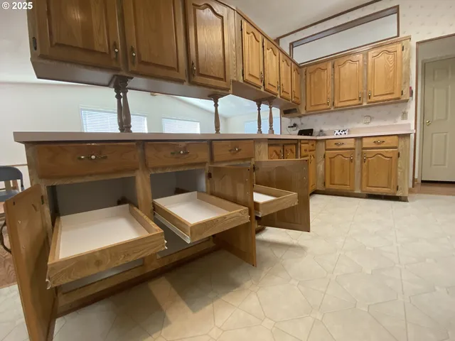 a utility room with stainless steel appliances granite countertop a sink dishwasher a stove and a refrigerator