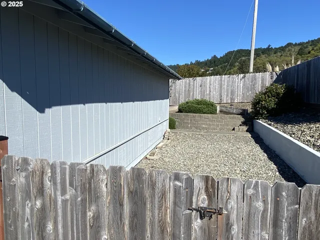 a view of a backyard with wooden fence