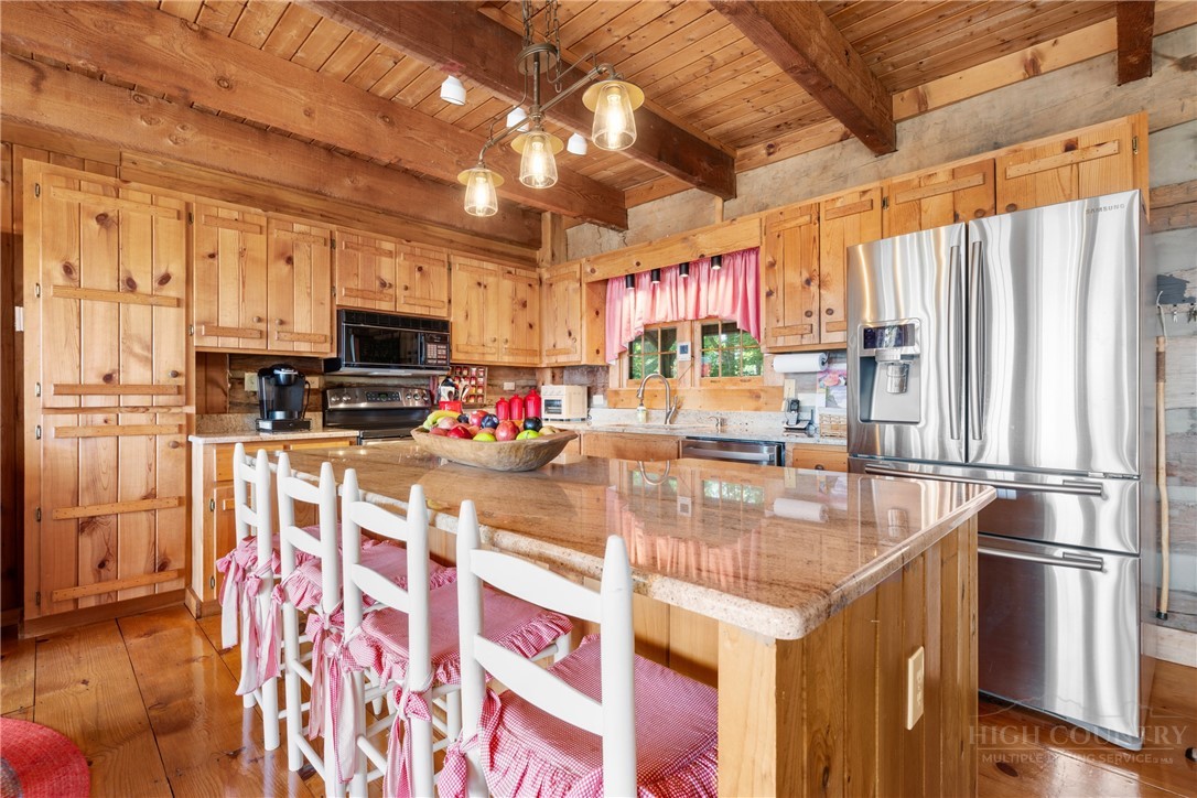 2177 Homestead Road Todd, NC 28684 - Photo 6 of 49 a kitchen with stainless steel appliances granite countertop a refrigerator a stove and a sink with wooden floor