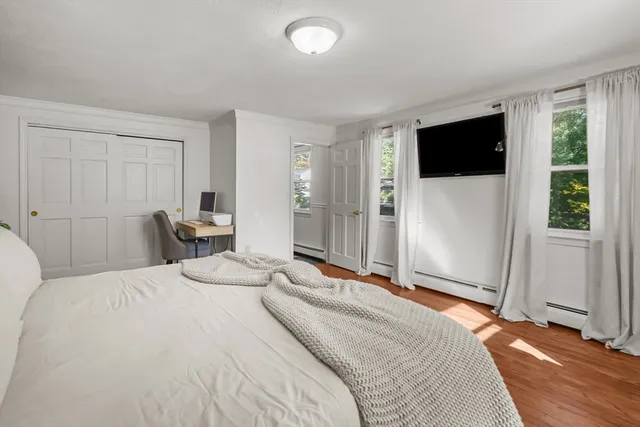 a bedroom with a large bed and a flat screen tv