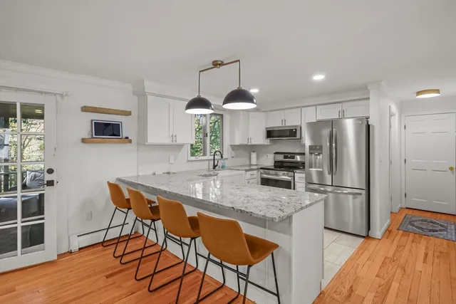 a kitchen with stainless steel appliances granite countertop a sink refrigerator and cabinets