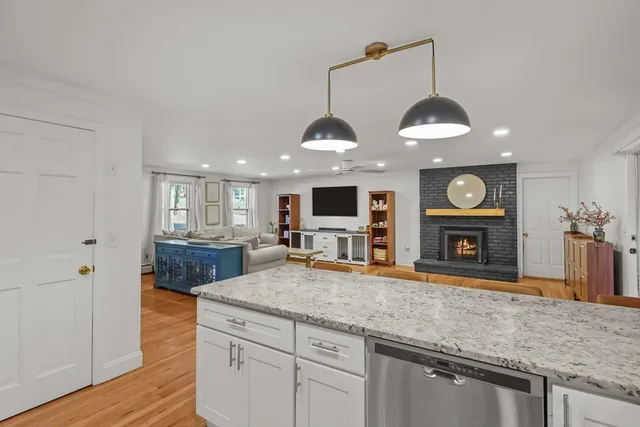 a kitchen with stainless steel appliances granite countertop a sink a stove and a wooden floors