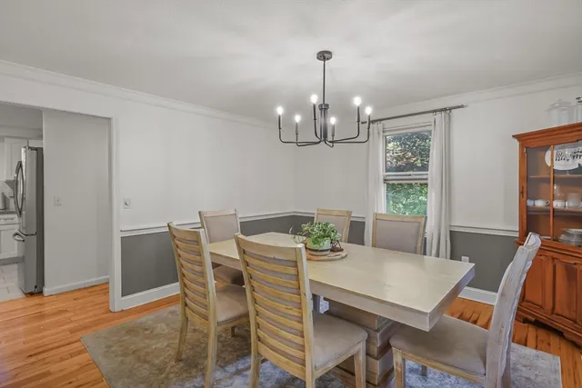 a view of a dining room with furniture a chandelier and wooden floor