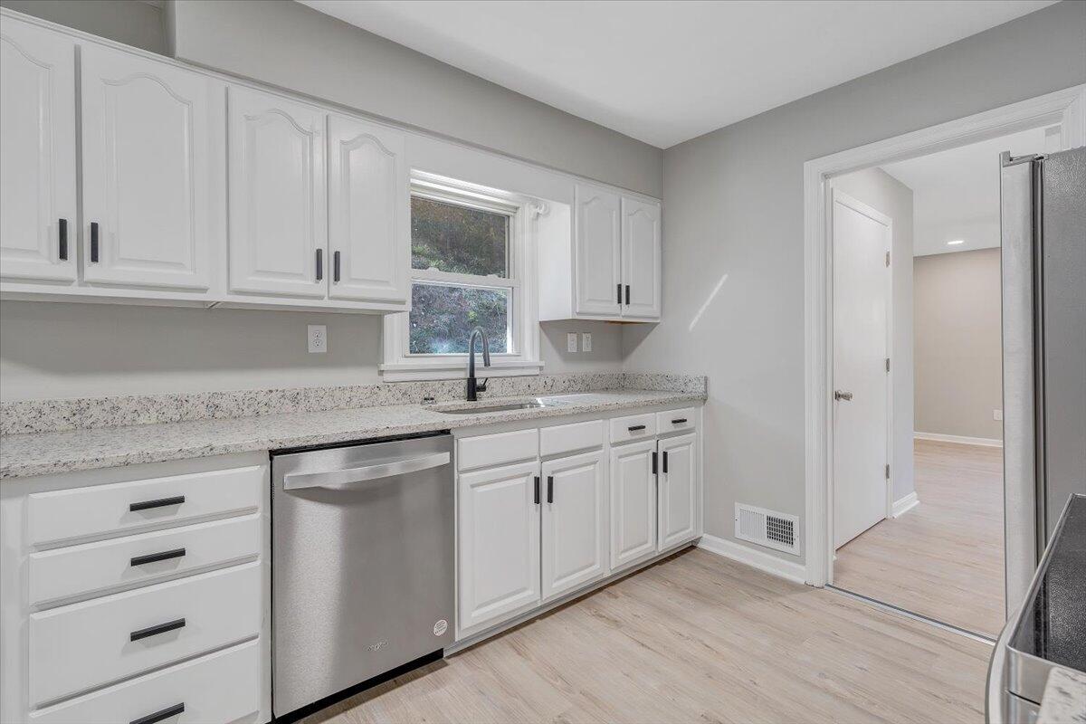 8633 Grassy Hill Road Boones Mill, VA 24065 - Photo 7 of 33 a kitchen with stainless steel appliances granite countertop a sink and dishwasher with white cabinets