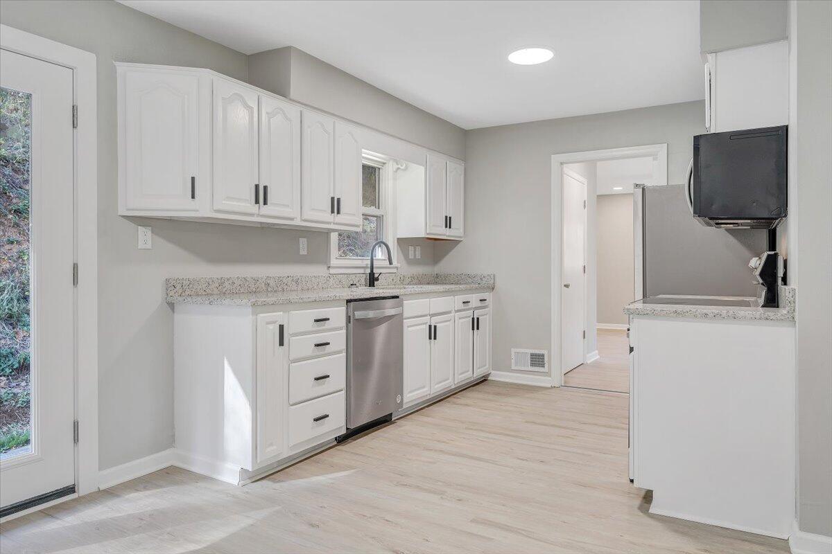 8633 Grassy Hill Road Boones Mill, VA 24065 - Photo 9 of 33 a kitchen with stainless steel appliances granite countertop a stove a sink and a refrigerator