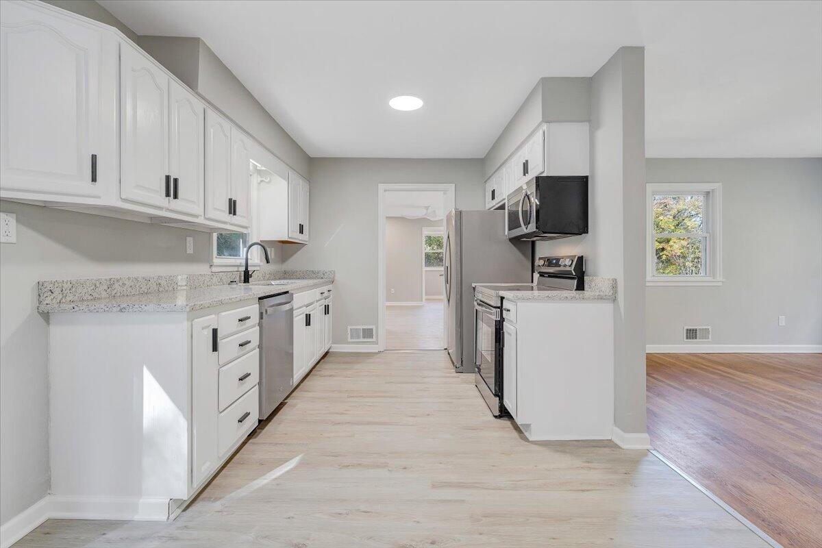 8633 Grassy Hill Road Boones Mill, VA 24065 - Photo 10 of 33 a kitchen with white cabinets and appliances