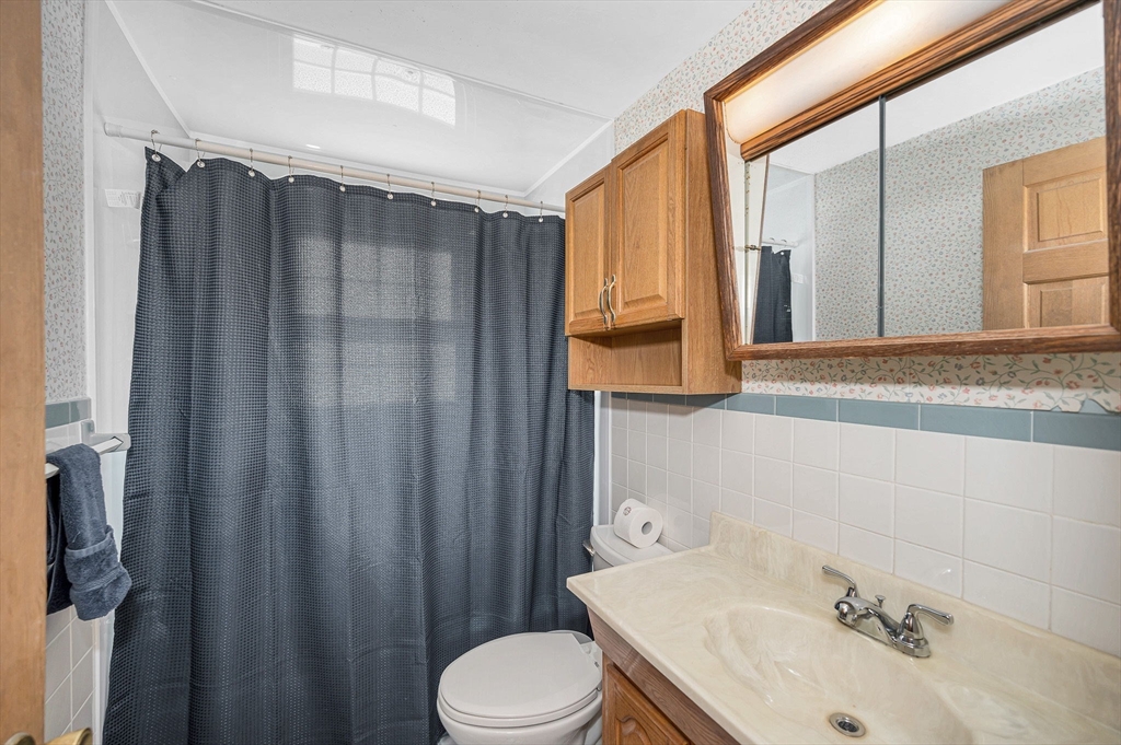 9 Harvard Road Billerica, MA 01821 - Photo 11 of 27 a bathroom with a sink a toilet and shower curtain
