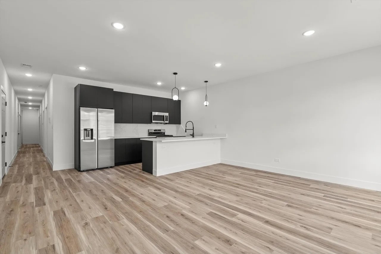 6538 South Rhodes Avenue, Unit 2 Chicago, IL 60637 - Photo 2 of 6 a open kitchen with kitchen island a sink dishwasher and a refrigerator with wooden floor