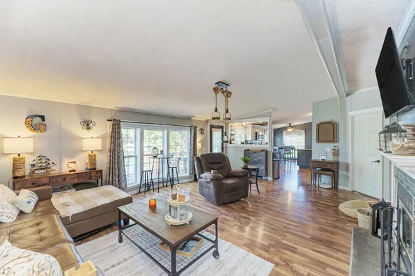 a living room with furniture flat screen tv and a large window