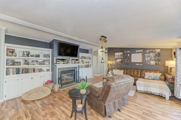 a living room with furniture a flat screen tv and a fireplace
