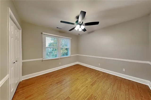 a view of a room with wooden floor and a ceiling fan