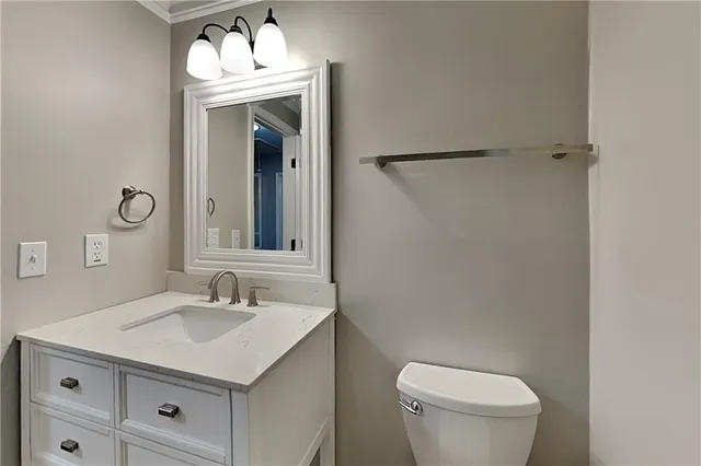 a bathroom with a sink vanity mirror and toilet