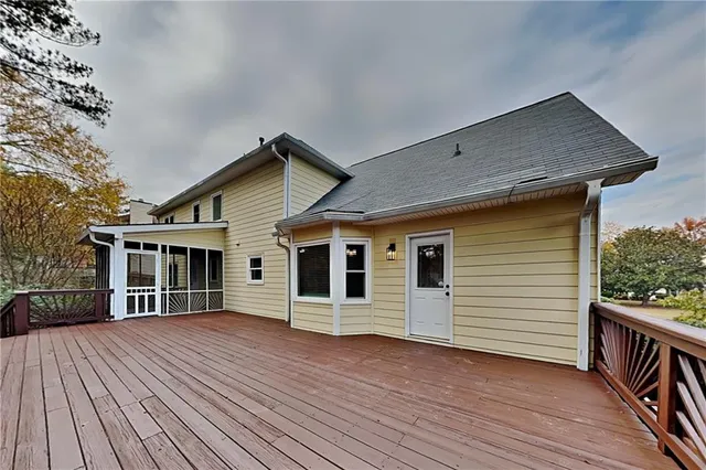 a view of a house with wooden deck front of house