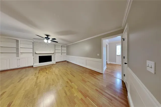 a view of empty room with wooden floor and fireplace